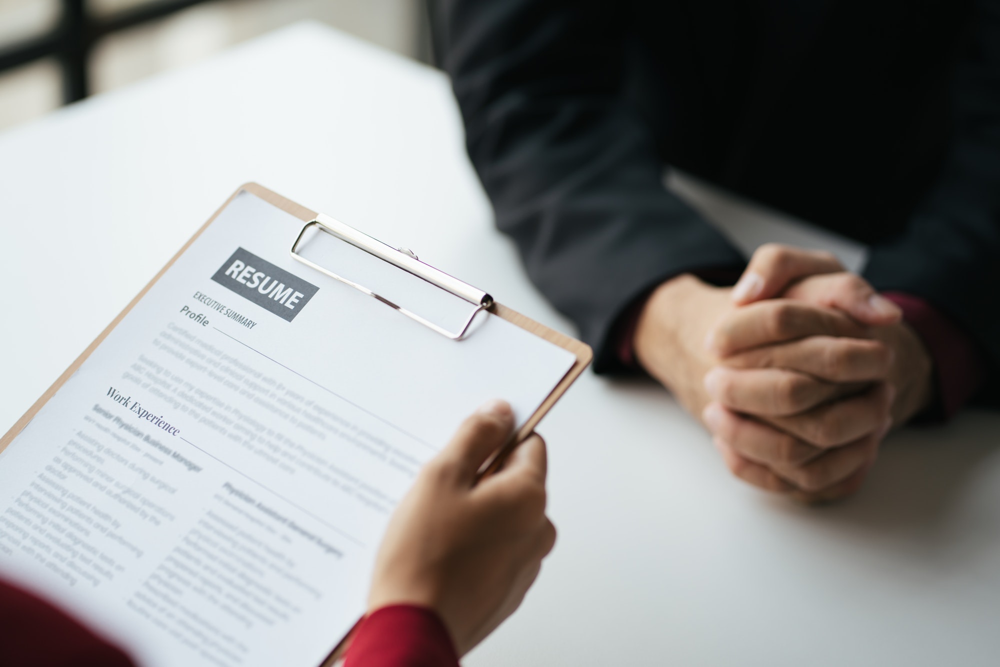 Close up view of employer reviewing resume of prepared skilled applicant during the interview.