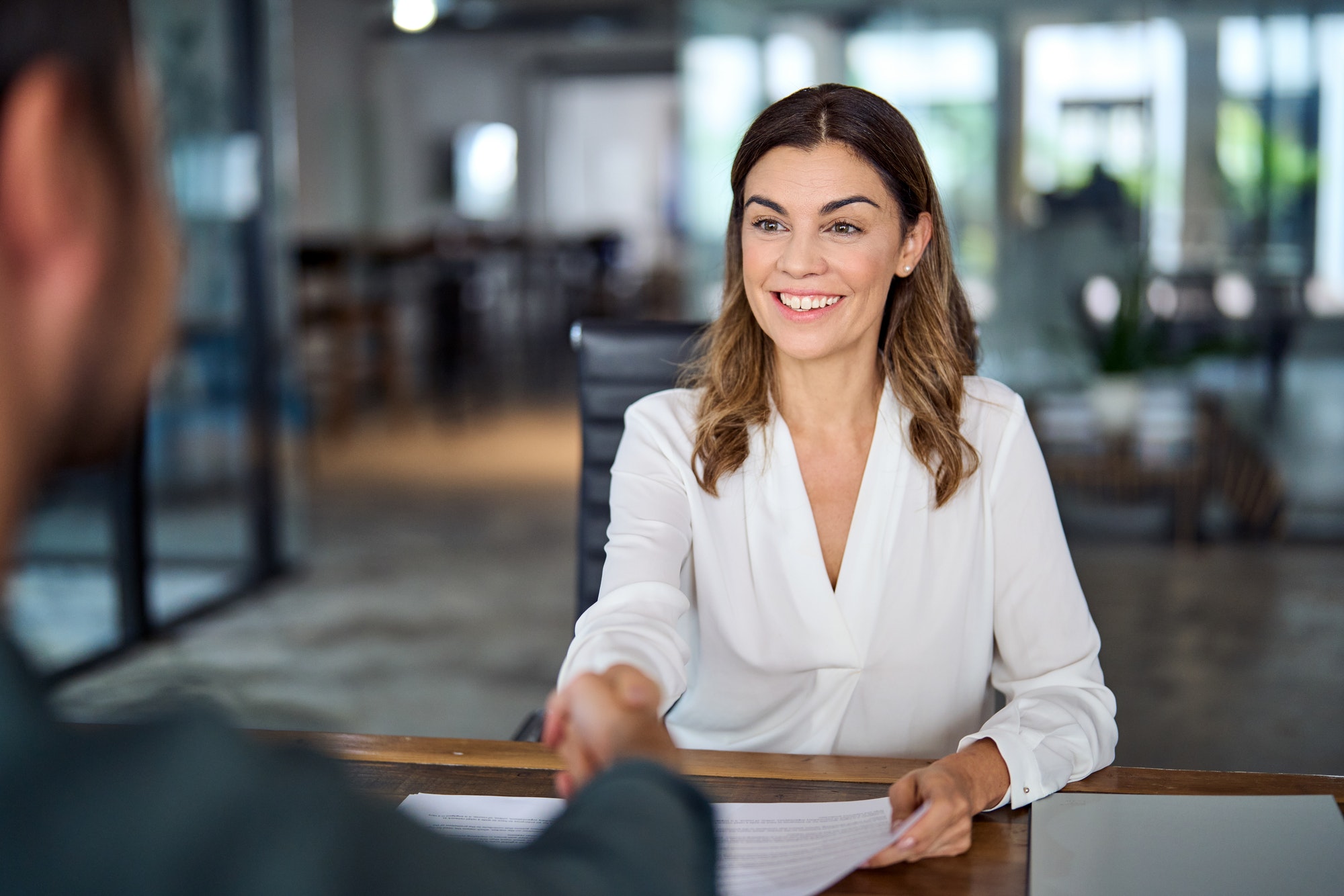 Smiling mature business woman hr handshaking hiring recruit at job interview.